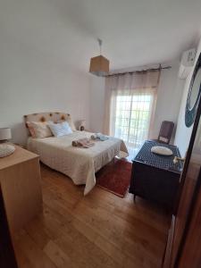 a white bedroom with a bed and a window at CASA DAS PEDREIRAS in Peso da Régua