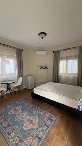 a bedroom with a bed and a table and a rug at Zaytoon Residence in Ulcinj