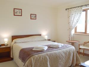 a bedroom with a bed with two towels on it at Pentre Cottage in Ferryside +3 photos