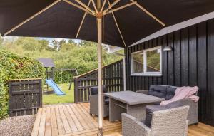 a patio with a table and chairs and an umbrella at Nice Home In Ebeltoft With Sauna in Ebeltoft