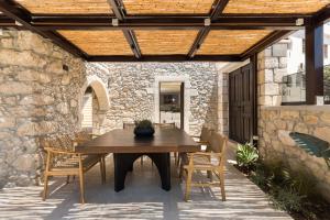 a patio with a table and chairs under a wooden ceiling at Vernardo's Heritage by Nest in Gerani