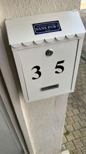 a white clock on the side of a building at Au Bon oranger, Appartement en coeur de ville hyper centre in Cholet