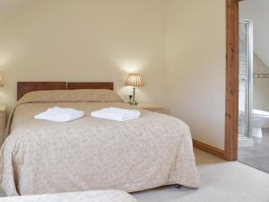a bedroom with a bed with two towels on it at Pentre Cottage in Ferryside