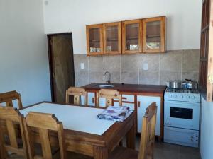 a kitchen with a table and a sink and a stove at Cabañas El Descanso de Animaná in Animaná