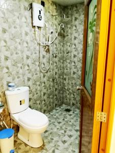 a bathroom with a toilet and a shower at Milk House Cottage in Udawalawe +36 photos