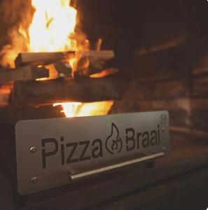 a pizza grill with a fire in the background at Unwinding Mossel bay in Mossel Bay