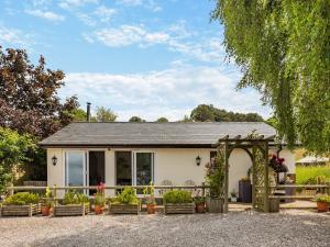 une maison avec une arche et des plantes en pot dans l'établissement Beehive Cottage, à Bodfari