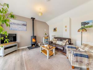 un salon avec un canapé et une cheminée dans l'établissement Beehive Cottage, à Bodfari