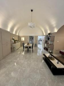 a large living room with a table and a kitchen at Dimora DiLeonardo in Carovigno