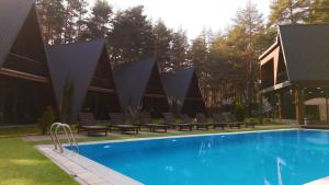 a swimming pool with benches next to a building at Park Hotel Surami Chalet in Surami +55 photos