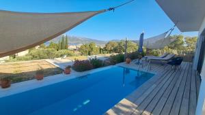 a swimming pool with a hammock on a deck at Villa Karma in Paleros