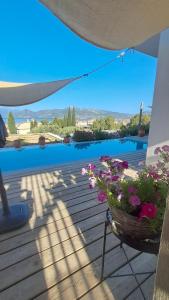 a balcony with a basket of flowers on a deck at Villa Karma in Paleros