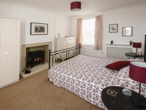 a bedroom with a bed and a fireplace at Barbican Cottage in Middleham