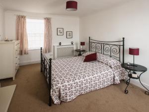 a bedroom with a bed and two tables and a window at Barbican Cottage in Middleham +5 photos