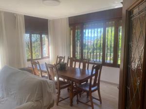 a dining room with a table and chairs and windows at VISTA BELLA - Logroño in Logroño