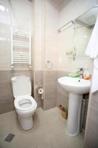 a white bathroom with a toilet and a sink at Marani Boutique in Tbilisi City +33 photos