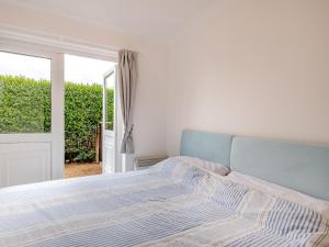 a white bedroom with a bed and a window at Sandy Toes in Hunstanton +2 photos