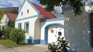 a small white and blue house with a door at Nationalpark Bauernhaus in Apetlon