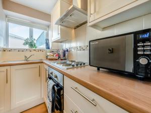 a kitchen with a counter with a microwave and a sink at Owl Cottage in Llandeilo