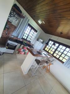 a kitchen with a table and chairs in a room at Chalé 3 com Hidro Acima das Nuvens in Campos do Jordão