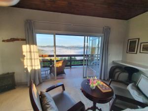 a living room with a view of the ocean at Chalé 3 com Hidro Acima das Nuvens in Campos do Jordão