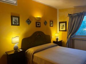 a bedroom with a large bed with yellow walls at Ciuci's Manor in Aragona