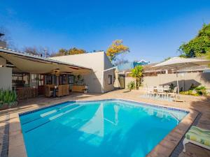 a swimming pool in front of a house at Eikelower Accommodation in Stellenbosch