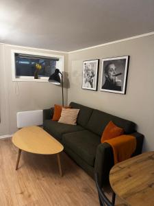 a living room with a green couch and a table at Apartment close to Aalesund center in Ålesund