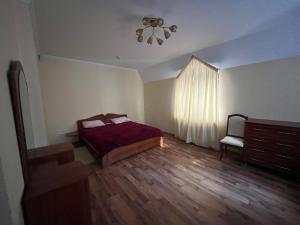 a bedroom with a bed and a dresser and a window at Центрум Делюкс in Lviv