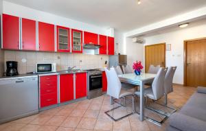 a kitchen with red cabinets and a table and chairs at Gorgeous Apartment In Razanj With Wifi in Ražanj