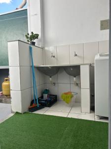 a kitchen with white cabinets and a green floor at Nossa casa, nosso lar in Belo Horizonte