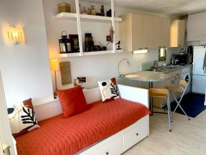 a room with a bed with pillows and a kitchen at Studio avec terrasse sud proche bord de mer in Sainte-Maxime