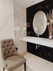 a bathroom with a chair and a mirror at Doade in Hio