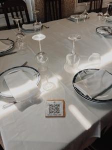 a table with white plates and glasses on it at Doade in Hio