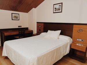 a bedroom with a large white bed and a desk at Doade in Hio