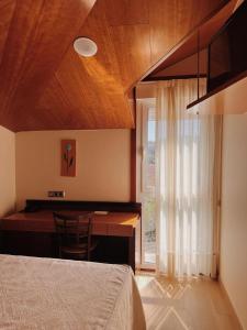 a bedroom with a bed and a desk with a window at Doade in Hio