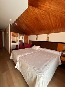 a bedroom with a large bed with a wooden ceiling at Doade in Hio