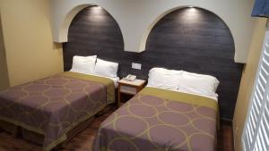 2 camas en una habitación con paredes arqueadas en Reedley Inn en Reedley