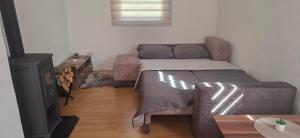 a small living room with a bed and a tv at Camp Krivace in Pljevlja