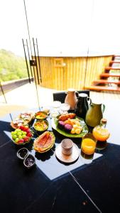 a black table with plates of food on it at Chalé 3 com Hidro Acima das Nuvens in Campos do Jordão +12 photos