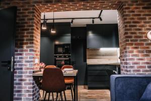 戈里察Karma Chic&Style Appartamento 1的厨房配有黑色橱柜和桌椅