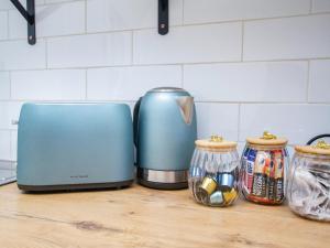 a kitchen counter with a blue toaster and two jars at Eikelower Accommodation in Stellenbosch
