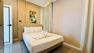 a bedroom with a bed with a towel on it at Auqa Pool Villa by DRH in Ban Bung