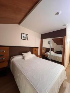 a bedroom with a large white bed and a mirror at Doade in Hio