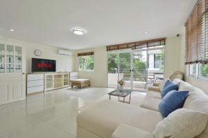 a living room with a white couch and a tv at UrbanLoft Sukhumvit 5BR Bangkok 5 min BKK Hospital in Ban Sam Ngam