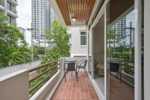 a balcony with two chairs and a table on it at UrbanLoft Sukhumvit 5BR Bangkok 5 min BKK Hospital in Ban Sam Ngam