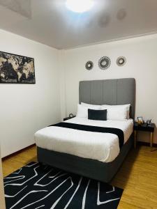 ハボローネにあるRibbon 210's Two bedroom apartmentの大きなベッドとラグのある寝室