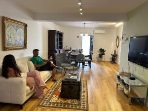 Un uomo e una donna seduti in un soggiorno di Faro Station Eleven Guest House a Faro Altre 21 foto