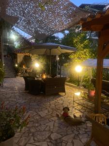 a dog laying on the ground under an umbrella at Pislis Rooms in Kamena Vourla