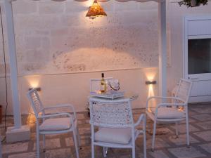 een tafel en stoelen met een fles wijn erop bij B&B Corte dell' Idume in Lecce